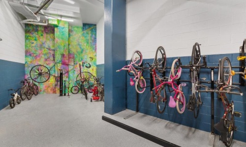 a room with a wall of bicycles