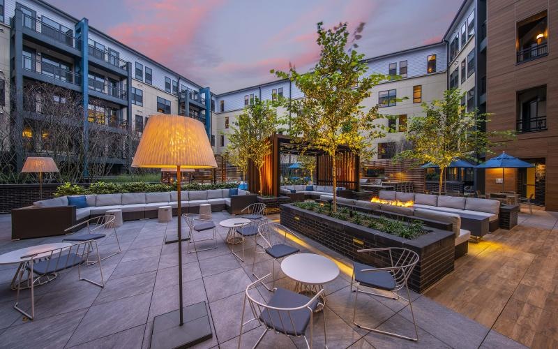 a courtyard with tables and chairs and umbrellas